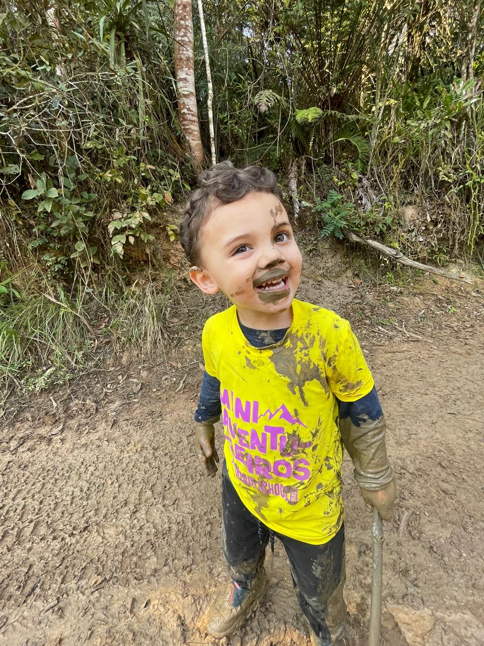 Mini Aventureiro coberto de lama na trilha
