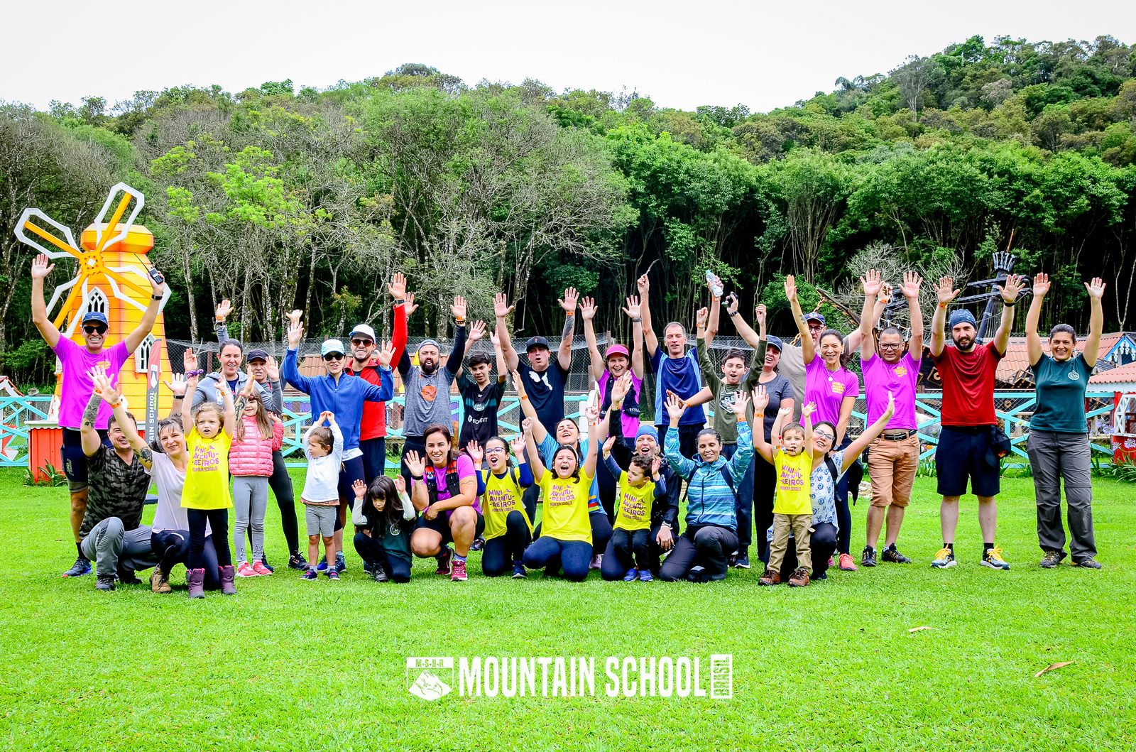Grupo Mountain School com mãos para o alto
