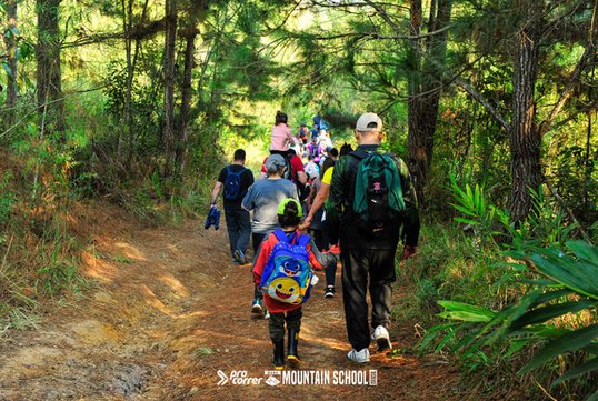 Crianças caminhando na trilha com os pais